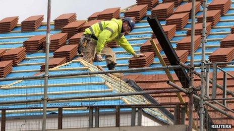 A builder works on the roof of a new residential property in north London