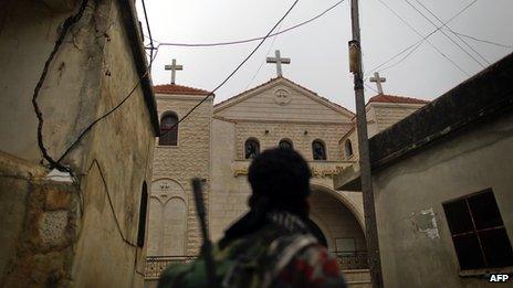 A rebel fighter looks at a church in Halassamiya (24 November 2012)