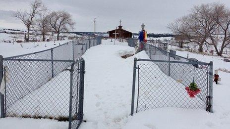 A snowy, fenced in area in front of a church