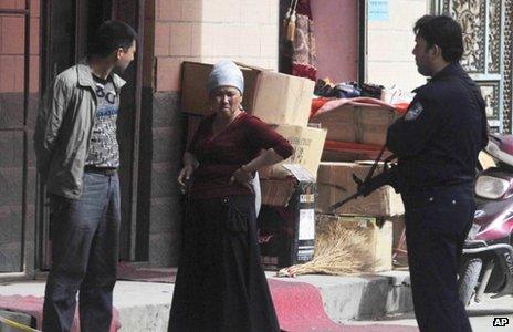 Local people speak to a police officer in Kashgar (25 April 2013)