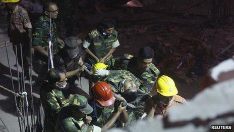 A rescuer injured in the fire is taken from the scene in Savar, Dhaka, Bangladesh