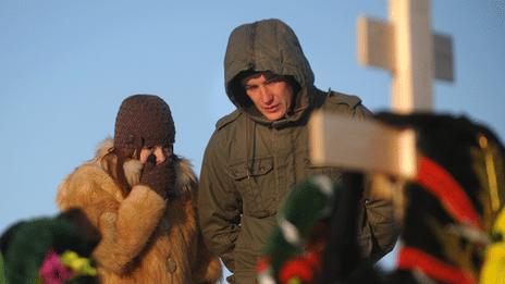 Mourners at the grave of fire victim Timur Prokofiev in a cemetery outside Perm, Russia, 6 December 2009