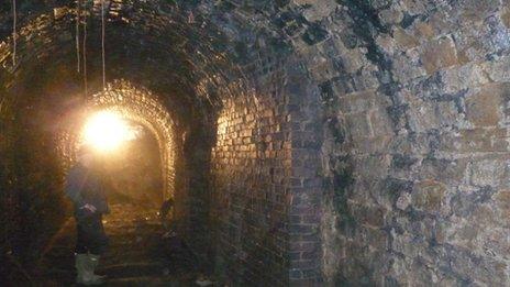 An archaeologist stands inside the tunnel at Fritchley