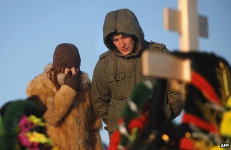 Mourners at the grave of fire victim Timur Prokofiev in a cemetery outside Perm, Russia, 6 December 2009