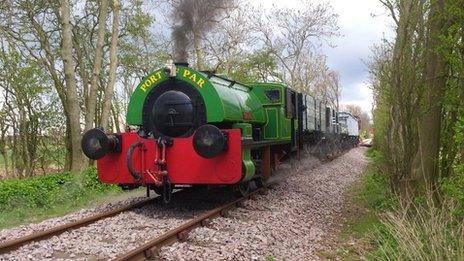 A steam train pulls wagons down the restored branch line.