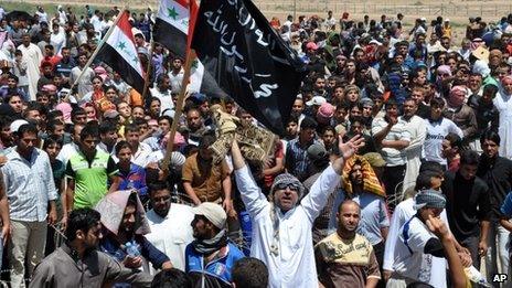 Masked Sunni protesters wave Islamist flags at an anti-government rally in Fallujah on 26 April