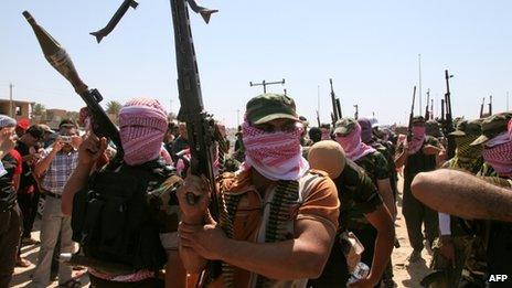 Iraqi anti-government gunmen from Sunni tribes in Anbar province march at a protest in western Baghdad on 26 April