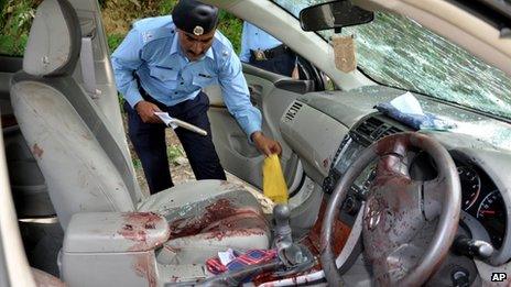 A police officer examines the car of prosecutor Chaudhry Zulfikar Ali