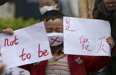 A child holds up protest posters in Kunming, China, 4 May