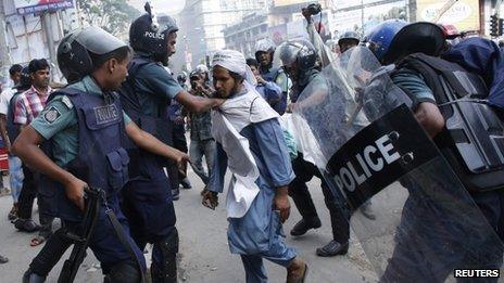 Police try to detain an activist during a clash in front of the national mosque in Dhaka, 5 May 2013