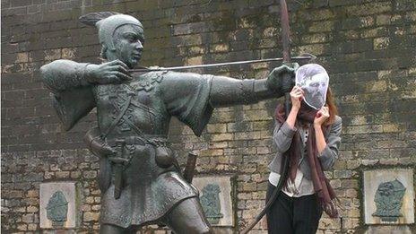 A fan poses at the Robin Hood statue in Nottingham.