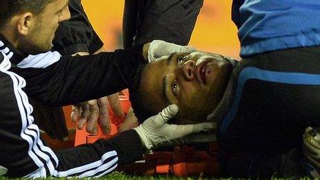 Michel Vorm is treated on the field at Wigan