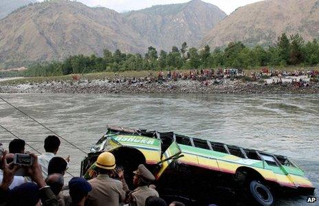 Rescuers look at a bus that plunged into the Beas River near Kullu, India, Wednesday, May 8, 2013