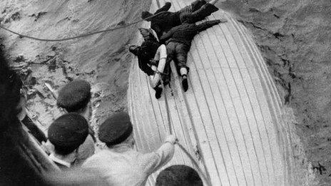 Survivors of the merchant ship 'Laconia', sunk during the Battle of the Atlantic, cling to a lifeboat after several days at sea before being rescued by a French cruiser