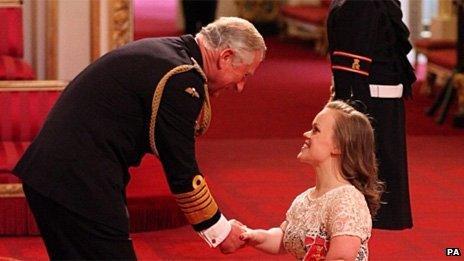 Ellie Simmonds receiving her OBE from Prince Charles