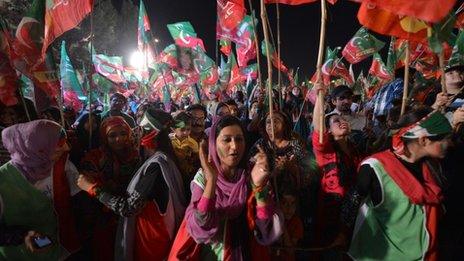 Supporters of Pakistani politician and former cricketer Imran Khan cheer as they wait to listen Khan video link address from a hospital during his last election campaign meeting in Islamabad on May 9, 2013