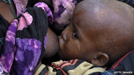 The child of a Somali refugee being breastfed by its mother at a Kenyan refugee camp