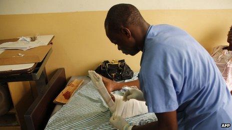 A nurse bandages Gerturde Sumbamala's left leg in a hospital in Accra, after it was broken in a crush in an evangelist church on 19 May 2013