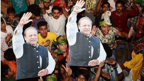 Supporters of former Pakistani Prime Minister and head of the Pakistan Muslim League-N (PML-N), Nawaz Sharif, carry portraits