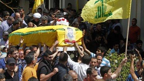 Men carry the coffin of a Hezbollah member allegedly killed while fighting in the Syrian town of Qusair, during his funeral in Beirut, Lebanon (22 May 2013)