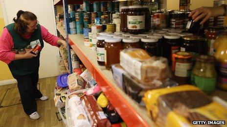 A volunteer stacks shelves at a food bank