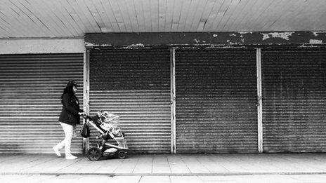 woman walks past closed shops