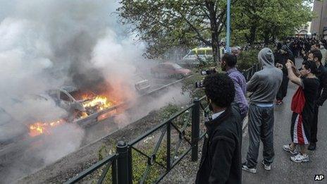 Bystanders watch burning cars in the Stockholm suburb of Rinkeby. 23 May 2013