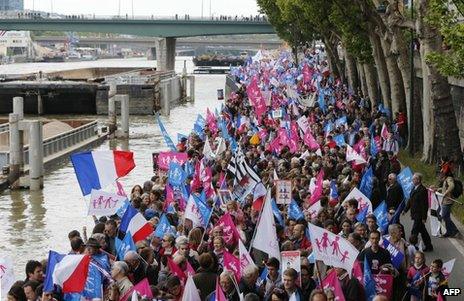 Demonstrators march along the Seine in Paris, 26 May