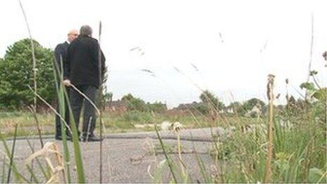 Residents stand on the site.