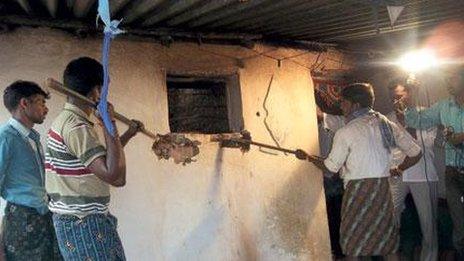 Officials use sticks to break into the room where Keshava had been confined for more than a decade