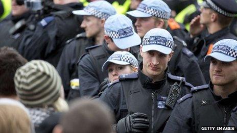 A police officer with blood on his face looks on as Unite Against Fascism (UAF) supporters protest