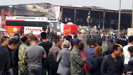 Crowds wait outside Jilin Baoyuanfeng factory in Mishazi, China. 3 June 2013