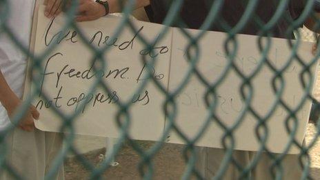 Guantanamo inmates hold up a sign