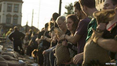 Volunteers pass sandbags to shore up flood defences in Dresden