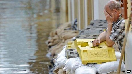 A man reacts outside a flooded house in Dresden