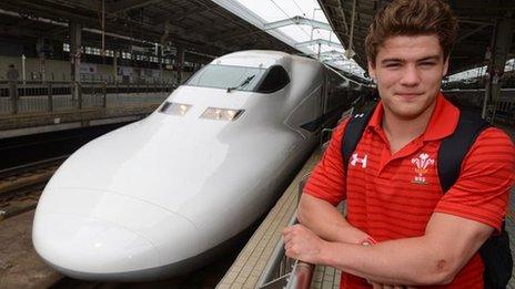 Wales wing Harry Robinson pictured alongside a Bullet Train in Japan