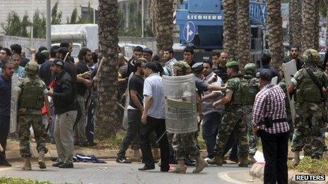 Lebanese soldiers and Hezbollah supporters are seen gathered in front of the Iranian embassy in Beirut
