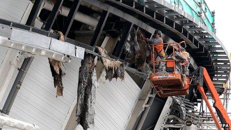 Workmen remove burnt insulation