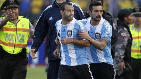 Argentina's Javier Mascherano is held by team-mate Ezequiel Lavezzi