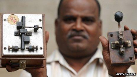 A telecommunications officer showing antique telegraph equipment used in sending messages through Morse code