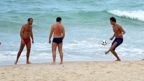 Men play football on Impanema beach in Rio de Janeiro, Brazil