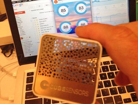 A Cubesensors product held up in front of a keyboard