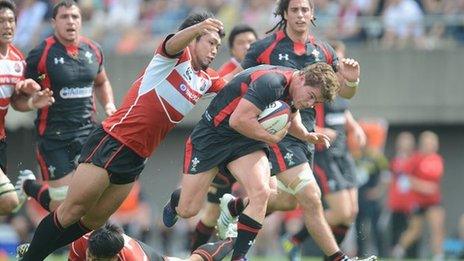 Harry Robinson of Wales is tackled by Hiroshi Yamashita of Japan