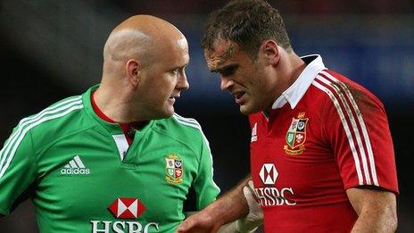 Jamie Roberts (right) is helped from the field by a medic