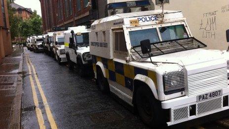 Police vehicles line the route of the march in Belfast