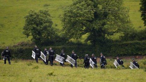 Riot police patrol the fields close to Lough Erne Golf Resort, Enniskillen