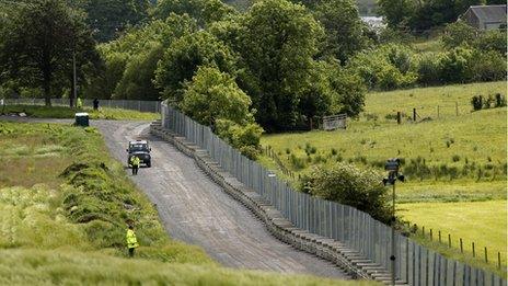 Police patrol the massive metal fence that surrounds the Lough Erne Golf Resort, Enniskillen