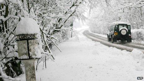 Car driving past a snow-covered sign in Derbyshire