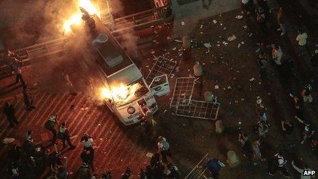 A vandalized press car from TV Record burns during a student demonstration in front of the City Hall