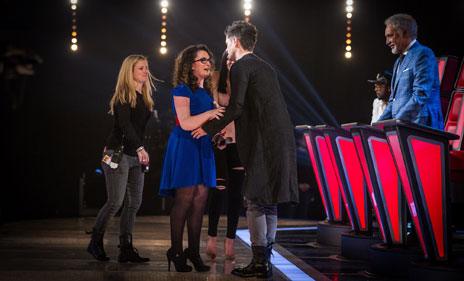 Danny congratulating Andrea, with a member of the production staff waiting to guide her from the stage